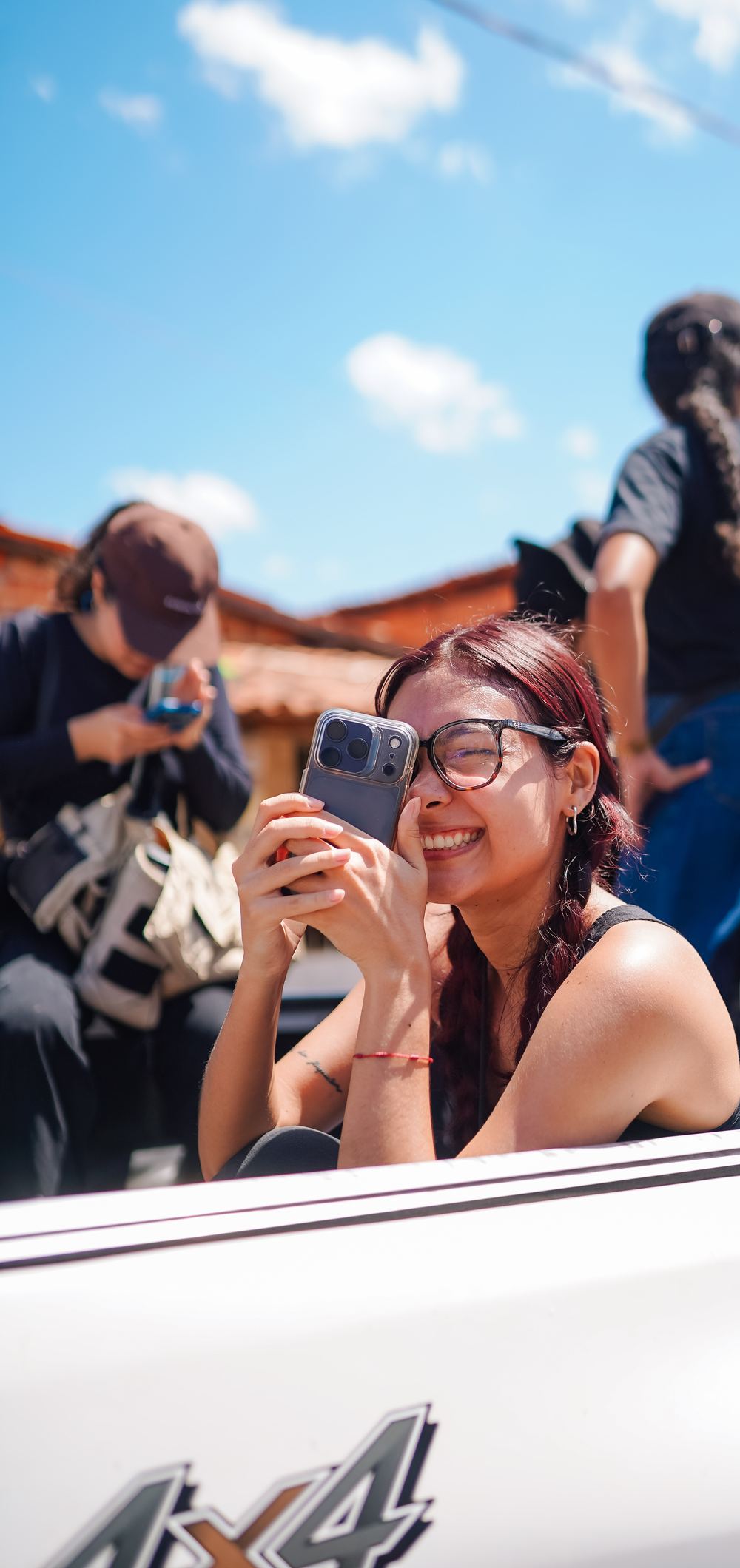 Manhã Galvão sorrindo enquanto filma com o celular durante uma gravação externa