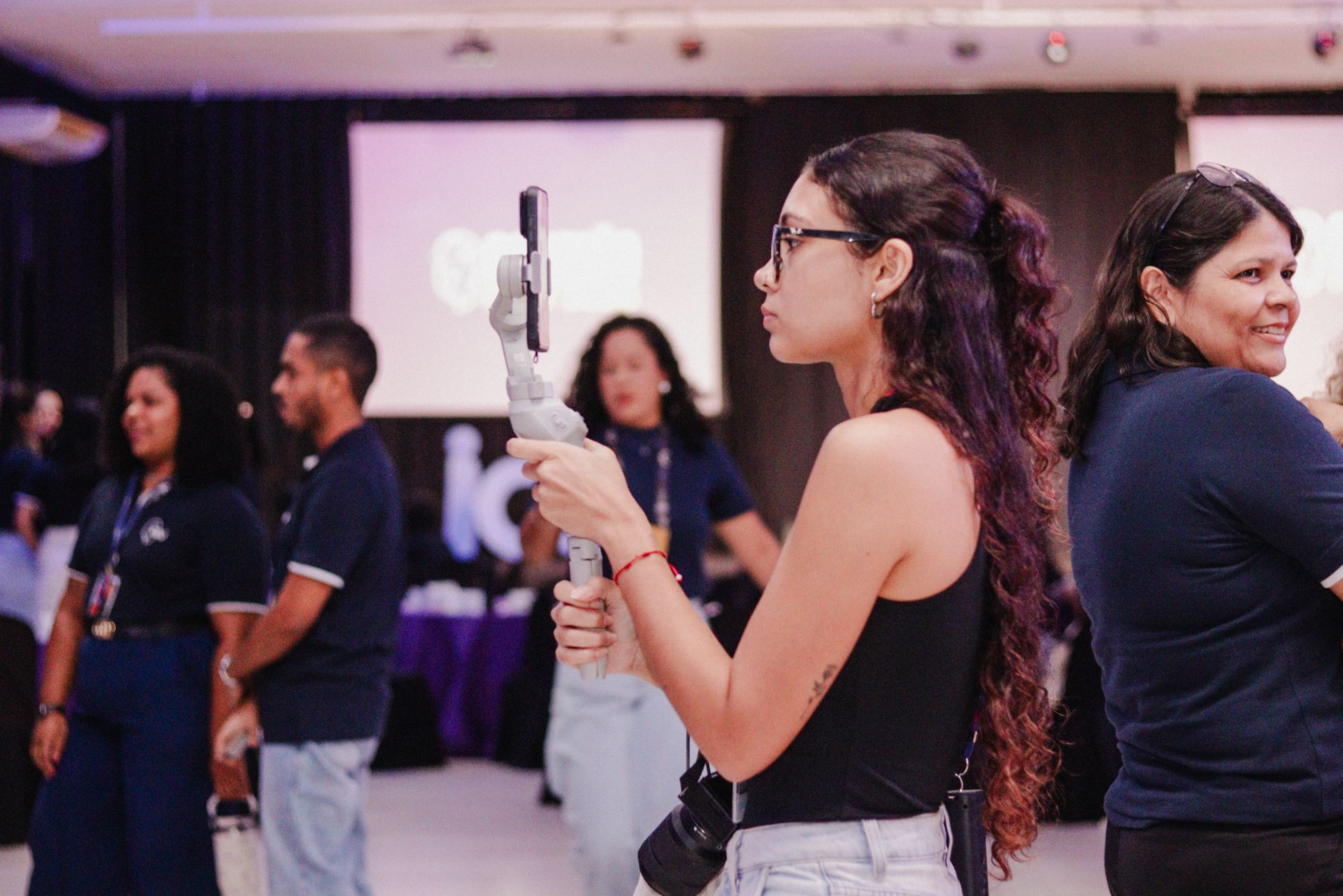 Manhã Galvão gravando com o celular num estabilizador durante um evento
